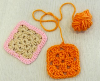余り毛糸で初めての編み物教室の作品見本。オレンジとピンクのコースター